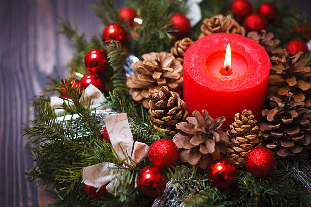 istock Red candle in a wreath of pine branches 614028376