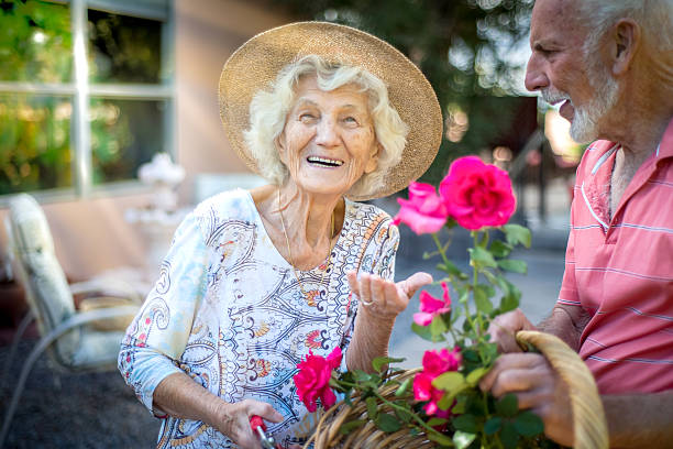 Happy senior people in the garden Happy senior people in the garden holding basket of roses. Albuquerque, USA. 80 89 years stock pictures, royalty-free photos & images