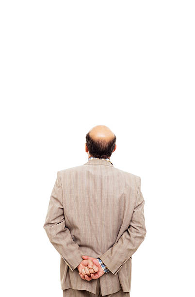 istock man in suit turned his back, taking  thoughtfully his wrist 614029612
