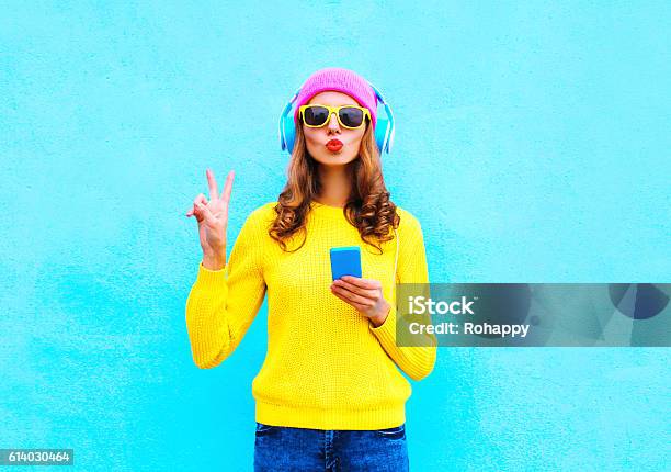 Fashion Pretty Woman Listening Music In Headphones With Smartphone Colorful Stock Photo - Download Image Now