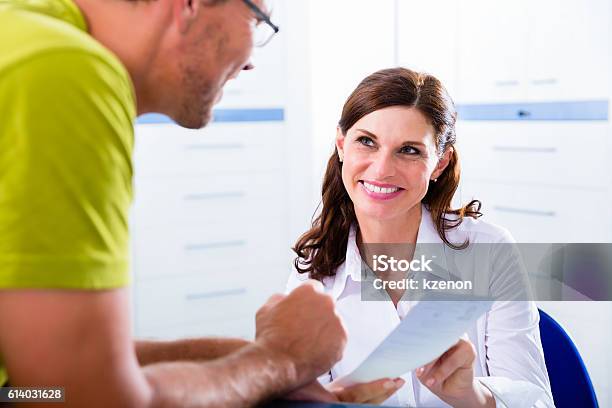 Patient At Reception Of Doctors Office Stock Photo - Download Image Now - Hospital, Patient, Receptionist
