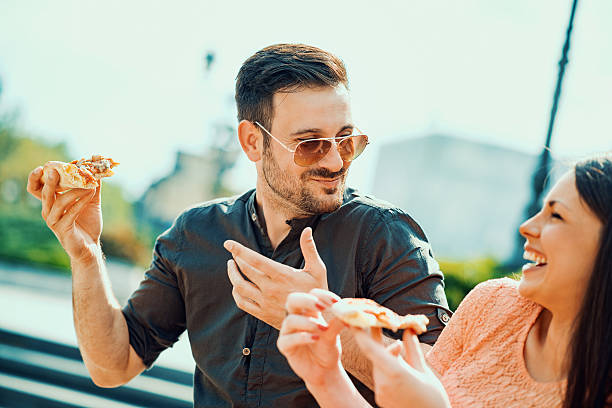 istock Happy couple eating pizza 614033434