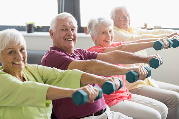 Seniors using weights Seniors using weights in a retirement home relaxation exercise stock pictures, royalty-free photos & images