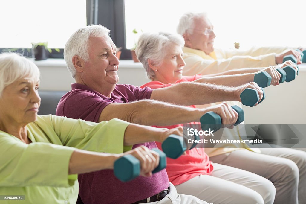 Seniors using weights Seniors using weights in a retirement home Senior Adult Stock Photo