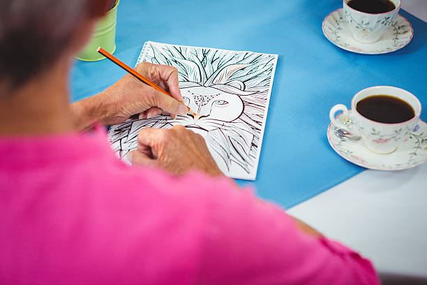 istock Lion drawing on a sheet of a paper with two cup of 614035156
