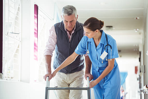 istock Nurse helping senior man with walking aid 614035660