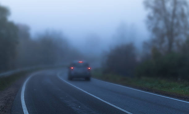 istock Car with red stoplights on foggy highway 614039000
