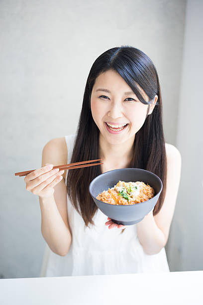 istock Woman eating Japanese meal 614040892