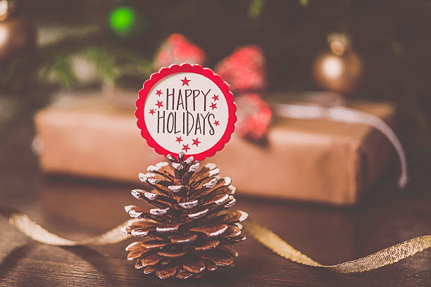 Christmas message with pinecone, gift, ribbon and decorations. Happy holidays