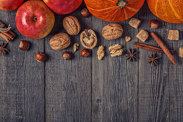 istock Wooden background with pumpkin, apples, nuts and spices. 614041746
