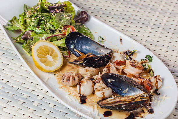 istock Seafood salad with greens and lemon on a plate 614041850
