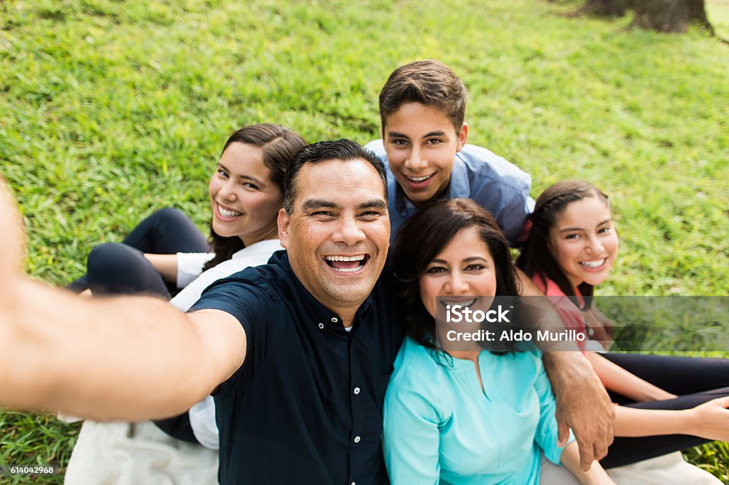 Happy latin familly taking a selfie outdoors A happy latin family of five taking a selfie and smiling in a horizontal medium shot outdoors. Family Stock Photo