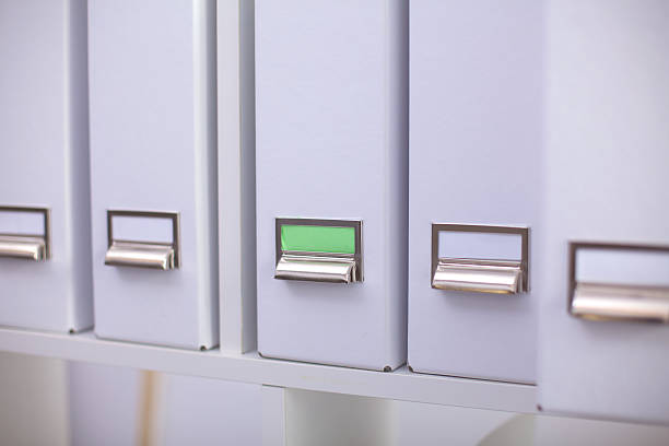 istock File folders, standing on shelves in the background 614043150
