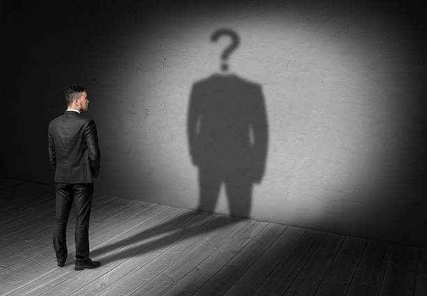 istock Businessman looking at question mark instead of head his shadow. 614043588