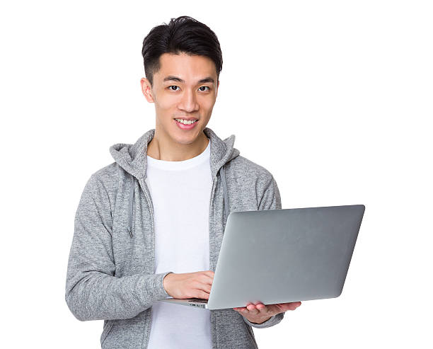 istock Asian man holding a laptop 614044934