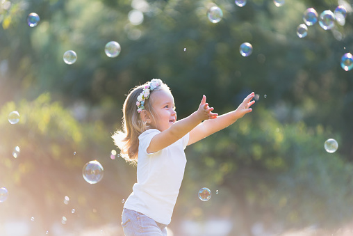 little girl playing with soap bubbles