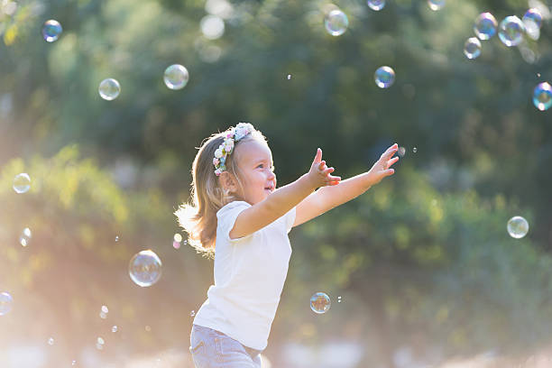 маленькая девочка играет с soap bubbles - little girls nature teenage girls small стоковые фото и изображения