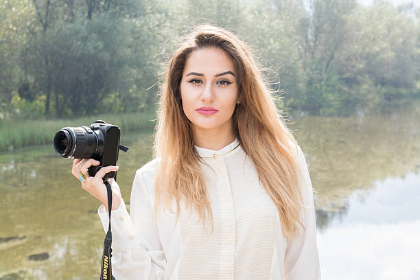 istock Beutiful Young Girl Posing With Photo Camera 614047078