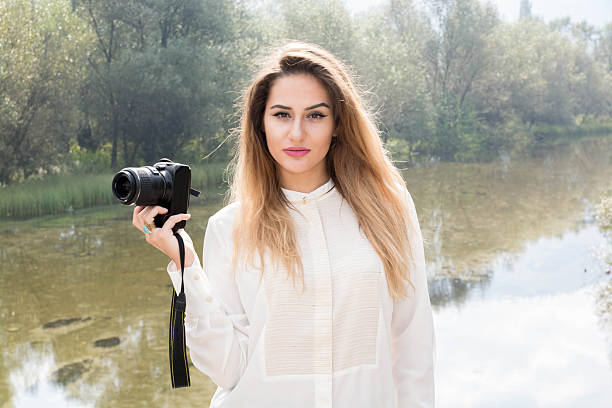 istock Beutiful Young Girl Posing With Photo Camera 614047116