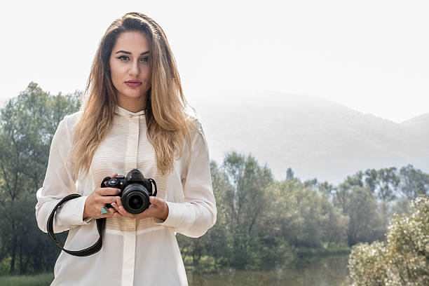 istock Beutiful Young Girl Posing With Photo Camera 614047186