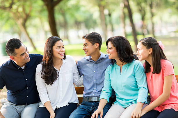 istock Family sitting on a bench looking at eldest daughter 614047500