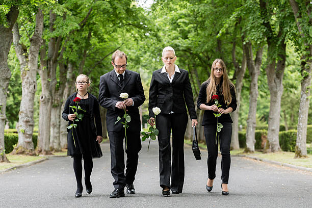 семьи ходьбе вниз alley в graveyard - funeral family sadness depression стоковые фото и изображения