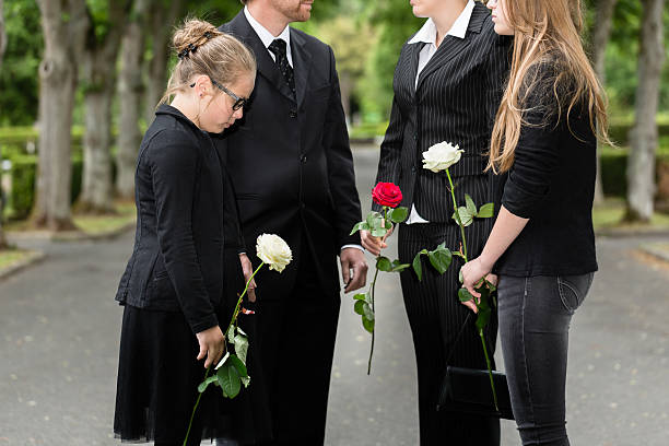 istock Family mourning on funeral at cemetery 614048644