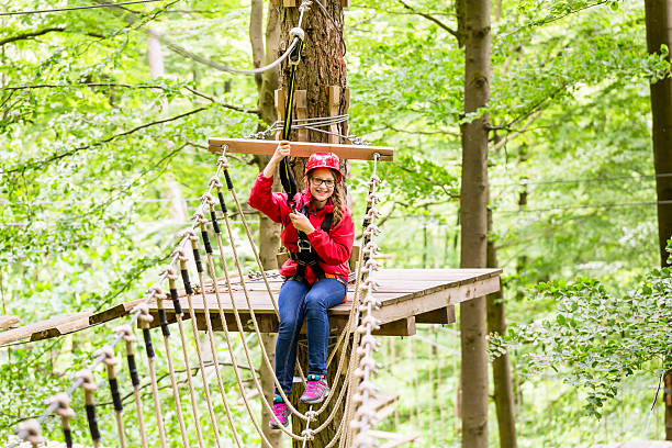 istock Child reaching platform climbing in high rope course 614050164
