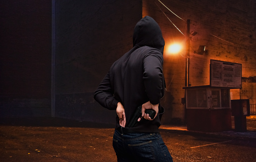 Burglar in action with gun at night