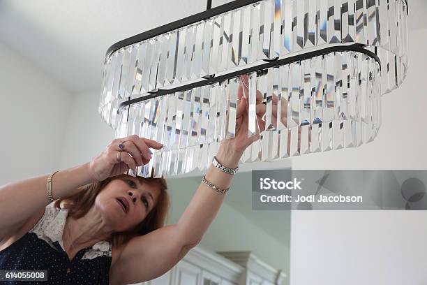 Serieshouse Staging Professional Female Stager Hanging Light Fixture Stock Photo - Download Image Now