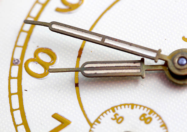 istock Closeup of hands on clock face 614056268