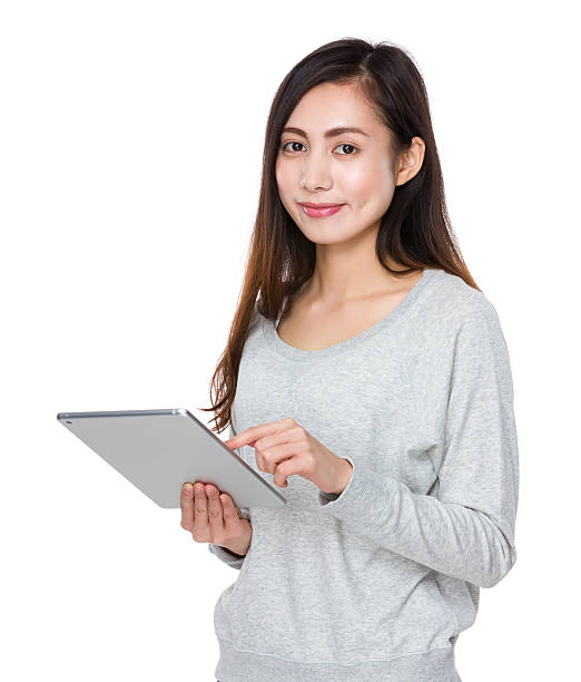 istock Asian young woman holding a tablet 614056488