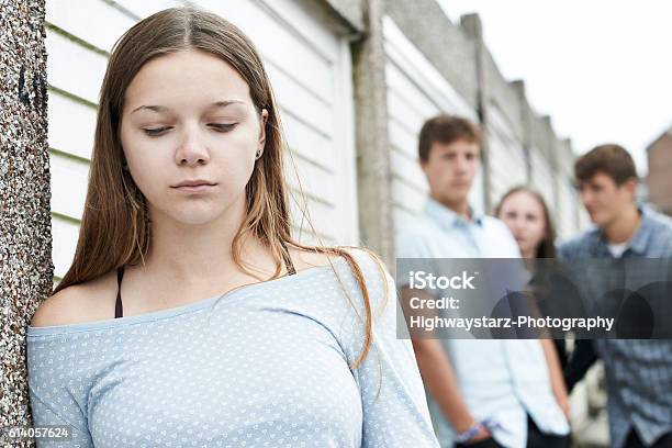 Unhappy Teenage Girl Being Talked About By Peers Stock Photo - Download Image Now - Bullying, Teasing, Teenager