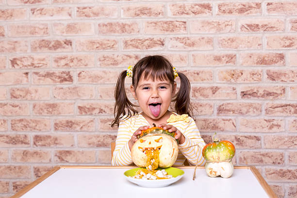 istock kid girl have fun pumpkin halloween 614057654