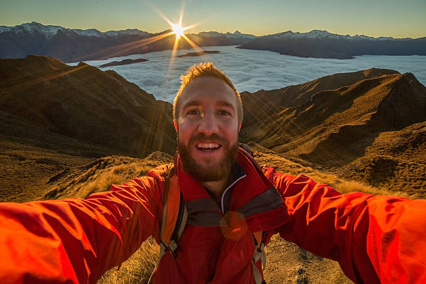istock Hiker takes selfie portrait on mountain peak above clouds 614108704