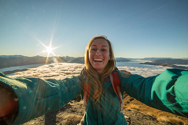 istock Young woman takes selfie on mountain summit 614109028