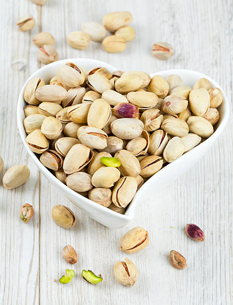 heart-shaped bowl full of pistachio nuts