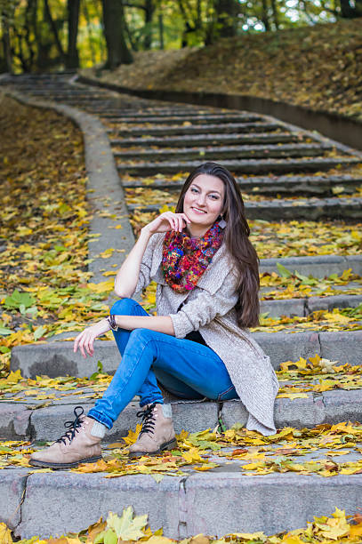 istock smiling girl sitting on the stairs 614110832