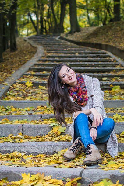istock smiling girl sitting on the stairs 614110924