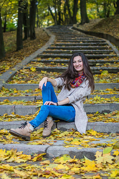 istock smiling girl sitting on the stairs 614110978