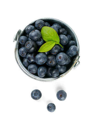 fresh blueberries in a bucket over white