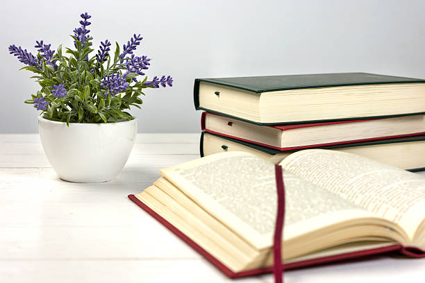 istock Stack of books on the table and a lavender plant 614113244