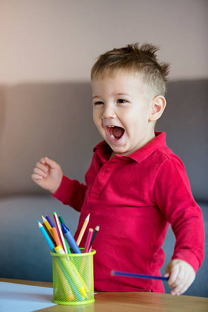 istock Happy little boy playing with coloring pencils 614114820