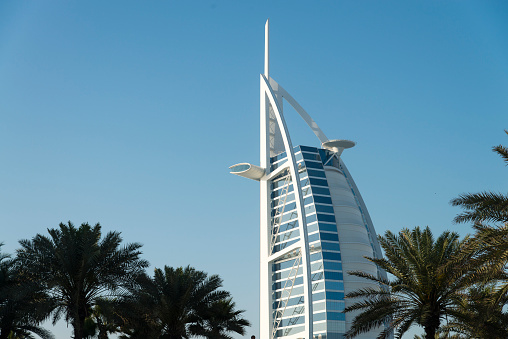 Dubai, United Arab Emirates - March 26, 2016: The top of the Burj Al Arab seen from the Madinat Jumeirah district in Dubai during the day. Burj Al Arab is the only seven star hotel in the world.