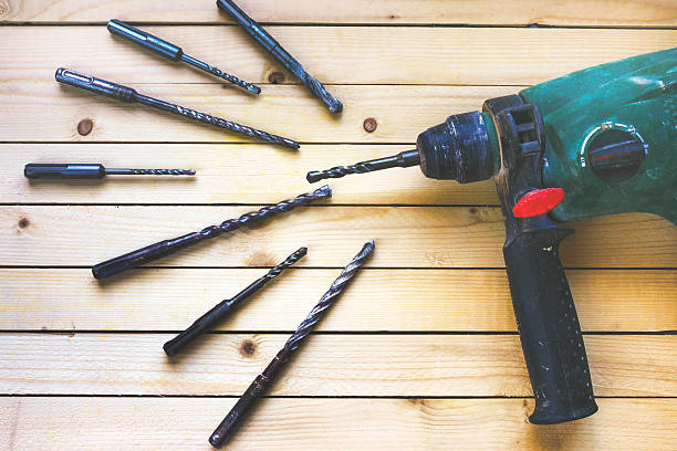 istock Electric hammer drill on wooden table with drill 614115846