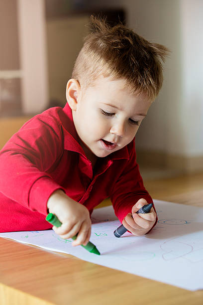 istock Young child holding crayons 614118266
