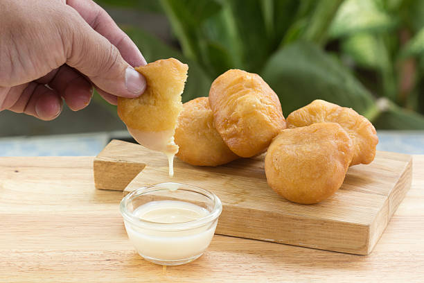 istock deep fried dough bun dip in sweetened condensed milk 614120102