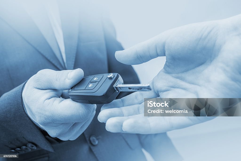 New Car Delivery Concept New Car Delivery Concept. Car Salesman Delivering New Vehicle. Giving New Car Keys. Blue Color Grading. Blue Stock Photo