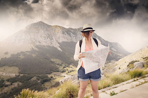 istock Woman traveler with map on high mountains 614122808