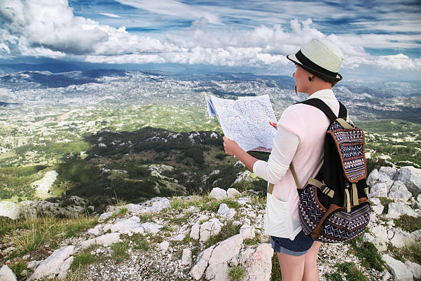 istock Woman traveler with map on high mountains 614122878